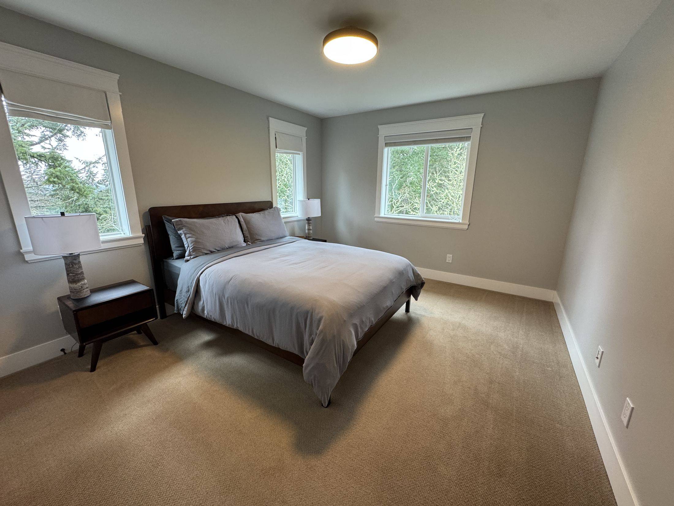 The grey room: queen bed with windows on two sides