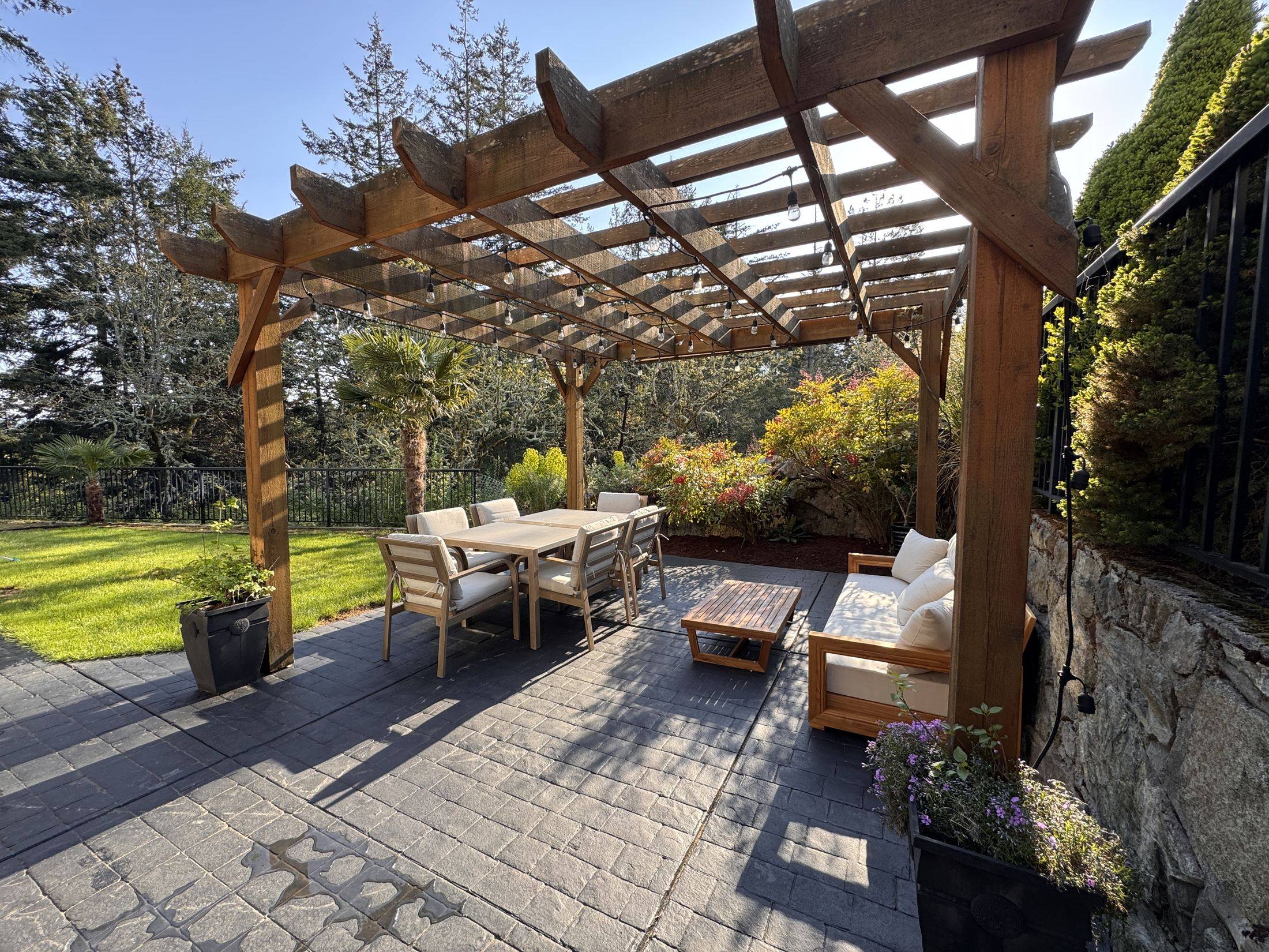 The cedar pergola: dining for six to eight and a lounge sofa
