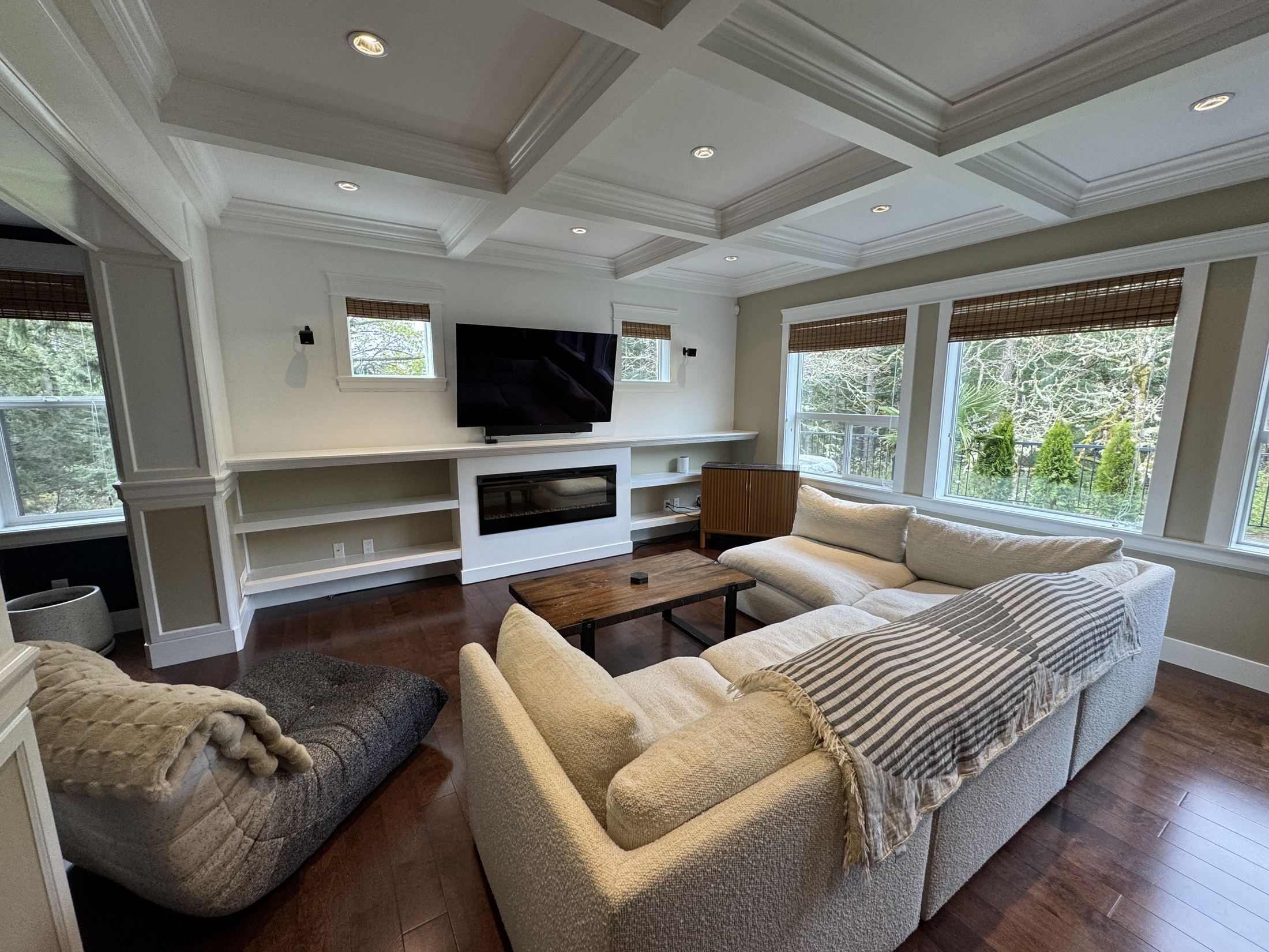 The living room: coffered ceiling, linear fireplace and a deep cream sectional